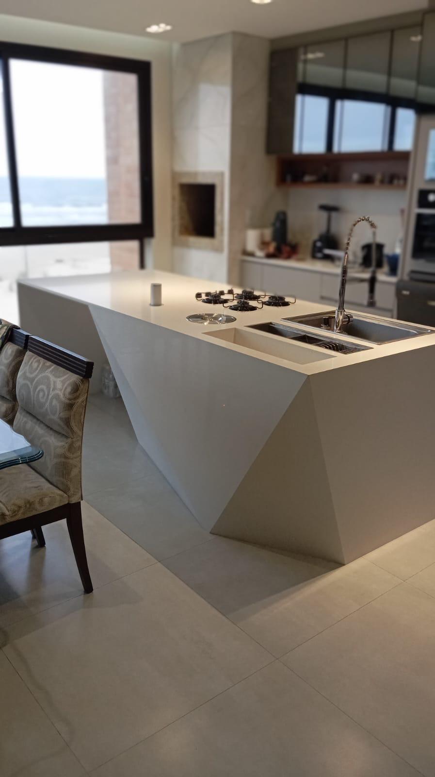 Cozinha com ilha geométrica esculpida em pedra