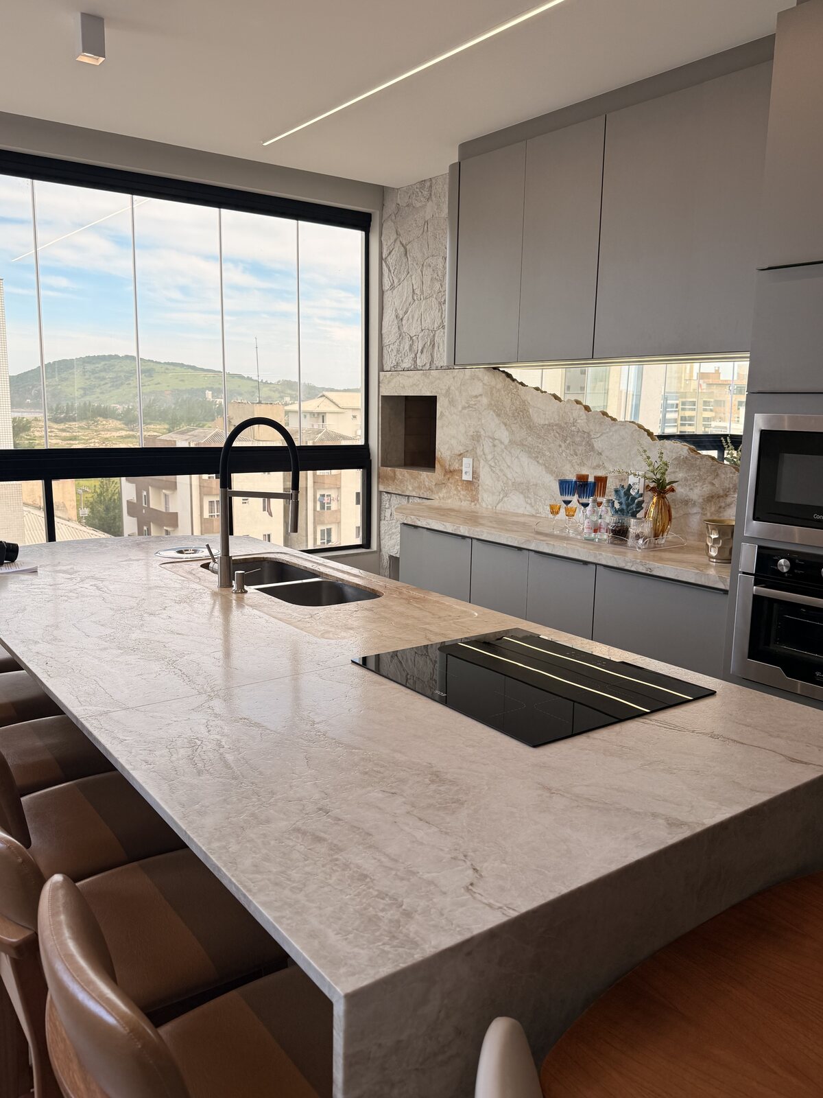 Cozinha com bancada em mármore e vista panorâmica