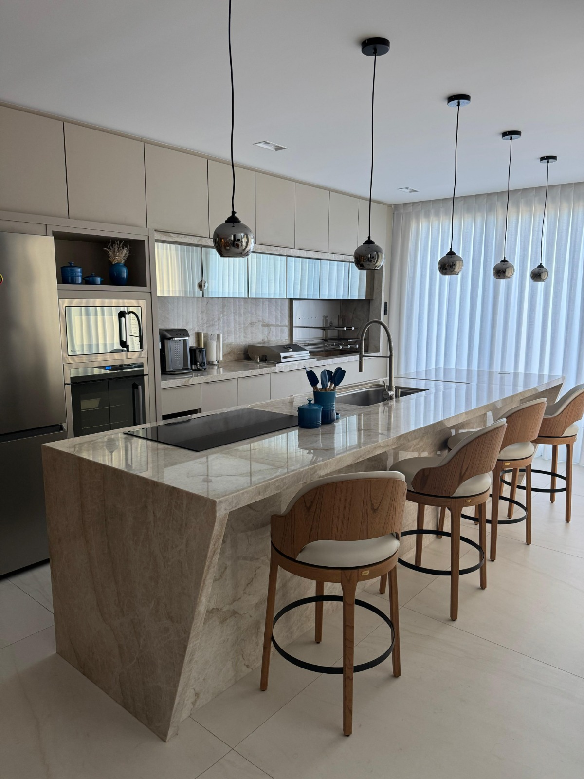 Cozinha gourmet com ilha em quartzito e pendentes