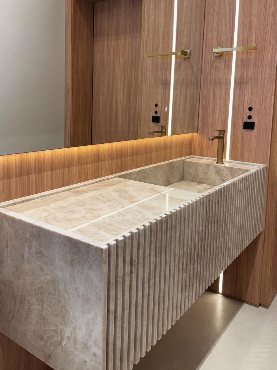 Lavabo com cuba esculpida e frente ripada em mármore